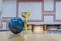 Closeup of blue bowling ball near golden trophy Royalty Free Stock Photo