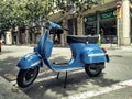 Closeup of a blue classic Piaggio Vespa scooter on the street