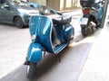 Closeup of a blue classic Piaggio Vespa scooter on the street