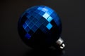 Closeup of a blue disco ball-shaped Christmas ornament, isolated on a dark background. Royalty Free Stock Photo
