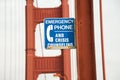 Closeup of a blue [Emergency Phone And Crisis Counseling] sign on a bridge with a blurry background Royalty Free Stock Photo