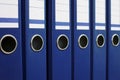 Closeup of blue file binders in a row on a shelf