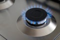 Closeup blue flame from a gas stove burner. Stainless steel kitchen surface. Royalty Free Stock Photo