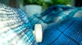 Closeup of a blue knitted texture with a white button Royalty Free Stock Photo
