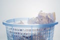 Closeup, Blue mesh waste bin filled of white paper against gradient background