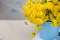 Closeup of blue metal bucket full of bright yellow dandelions. Flowers in vase. Summer. Outdoor