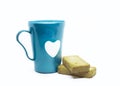 Closeup of a blue mug with a heart next to dry bread slices isolated on white background Royalty Free Stock Photo