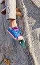 Closeup of leg and tennis shoe on rock climbing wall