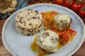 Closeup of blue plate on wood table with homemade minced meat balls gratinated with mozzarella cheese in fresh tomato sauce with Royalty Free Stock Photo