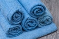 Blue rolled bath towels on wooden table in bathroom Royalty Free Stock Photo