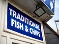 Closeup of a blue signboard of a traditional fish and chips shop near the sea