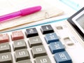 blue tax buttons on white calculator and pink ballpoint pen on pile of financial documents Royalty Free Stock Photo