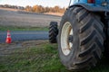 Closeup of blue tractor tire with agricultural field background