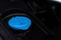 Closeup blue windshield washer fluid reservoir cap in engine room. Royalty Free Stock Photo