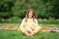 Expecting young female mother posing in park holding plush toy