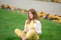 Expecting young female mother posing in park holding plush toy