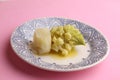 Closeup of boiled romanesco broccoli with potatoes in a plate on a pink surface Royalty Free Stock Photo
