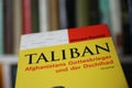 Closeup of book cover about taliban jihad on front of shelf