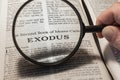 closeup of the book of Exodus from Bible or Torah using a magnifying glass to enlarge print.