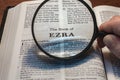 closeup of the book of Ezra from Bible or Torah using a magnifying glass to enlarge print. Royalty Free Stock Photo