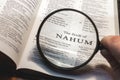 closeup of the book of Nahum from Bible or Torah using a magnifying glass to enlarge print. Royalty Free Stock Photo