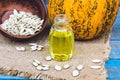 Closeup of a bottle of pumpkin seed essential oil on a napkin with burlap