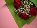 Closeup of a bouquet of beautiful red roses on a pink surface Royalty Free Stock Photo