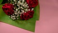 Closeup of a bouquet of beautiful red roses on a pink surface Royalty Free Stock Photo