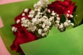 Closeup of a bouquet of beautiful red roses on a pink surface Royalty Free Stock Photo