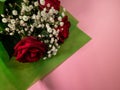Closeup of a bouquet of beautiful red roses on a pink surface Royalty Free Stock Photo
