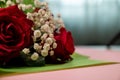 Closeup of a bouquet of beautiful red roses on a pink surface Royalty Free Stock Photo