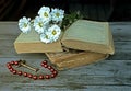 Bouquet of white flowers lying on two ancient books lying on a t Royalty Free Stock Photo