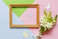 Closeup of the bouquet of white flowers, wooden frame and silhouettes of butterflies on the Pastel colors background