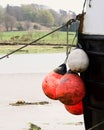 Closeup of the bow of a boat with three buoys