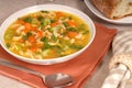 Closeup of a bowl of chicken noodle soup with rustic bread Royalty Free Stock Photo