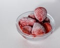 Closeup of a bowl of frozen sweet and tasty strawberries