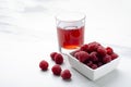 Closeup of bowl of raspberries and fresh sweet drink on the white marble surface.Empty space