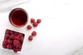 Top view of heap of sweet ripe raspberries and glass of drink on the white table.Empty space Royalty Free Stock Photo