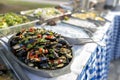 Closeup of a bowl of seafood salad with vegetables on the table under the sunlight