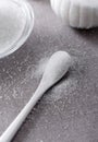 Closeup bowl and spoon with white sand on stone table background