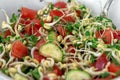 Closeup bowl with vegetable salad, microgreens, sprouts of cereals and green plants of broccoli, tomatoes, cucumbers, oil, salt, p