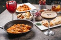 Closeup of bowls of cooked pasta with salads, delicious cocktails, and fried vegetables on the table