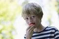 Closeup Of Boy Eating Strawberry Outdoors Royalty Free Stock Photo