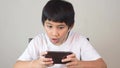 Asian boy playing games on his smartphone.