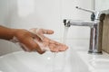 Closeup of a boy scrubbing soapy hand against washbasin