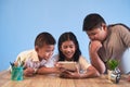 Closeup of boys and a girl experiencing digital learning using a tablet