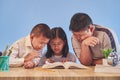 Closeup of boys and a girl experiencing digital learning using a tablet