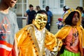 Closeup boys in golden masks and pied carnival costumes pass by dominican city street