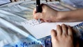 Closeup boys hand writing christmas card to his friend