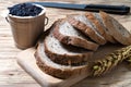 Closeup bread loaf and wheat ears and berries rice on wooden background